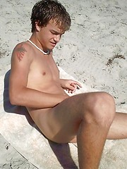 Cute young twink exposing his ass and cock on the sandy beach.