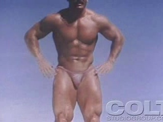 Sexy beefy gay man shows his athletic muscles to the camera