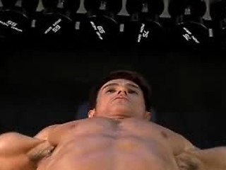 Very awesome dude exercising and lifting weights in a gym