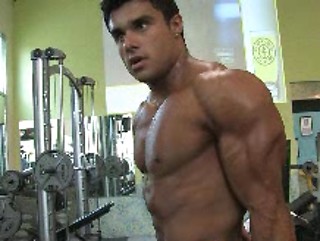 Bodybuilder Tony Searle shows his muscles in a gym