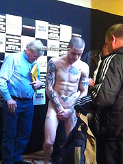 The heavily tattooed tough guy demurely stands on the scales covering his cock and balls by Ruggerbugger image #5