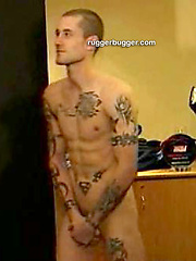 The heavily tattooed tough guy demurely stands on the scales covering his cock and balls by Ruggerbugger image #5