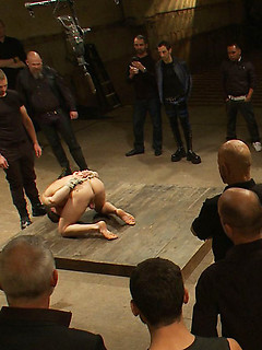 A stud endures brutal face and ass fucking by a crowd of strangers while suspended upside down.