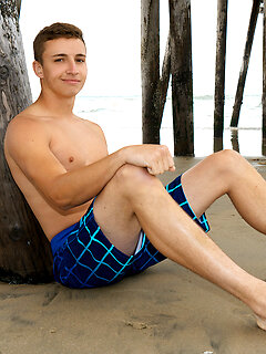 Young Gibson poses on the beach then goes inside and strips to show his cock